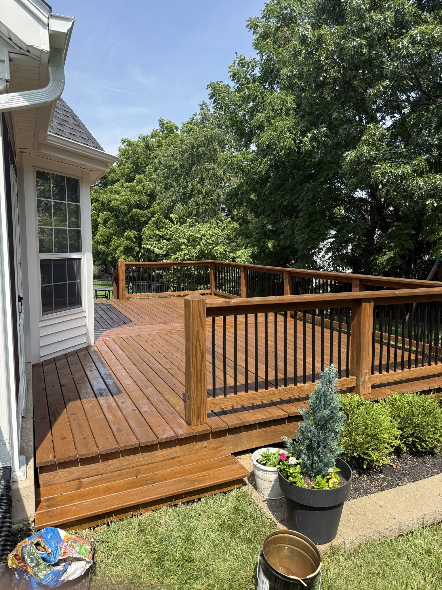 Finished deck corner with black railing and planters